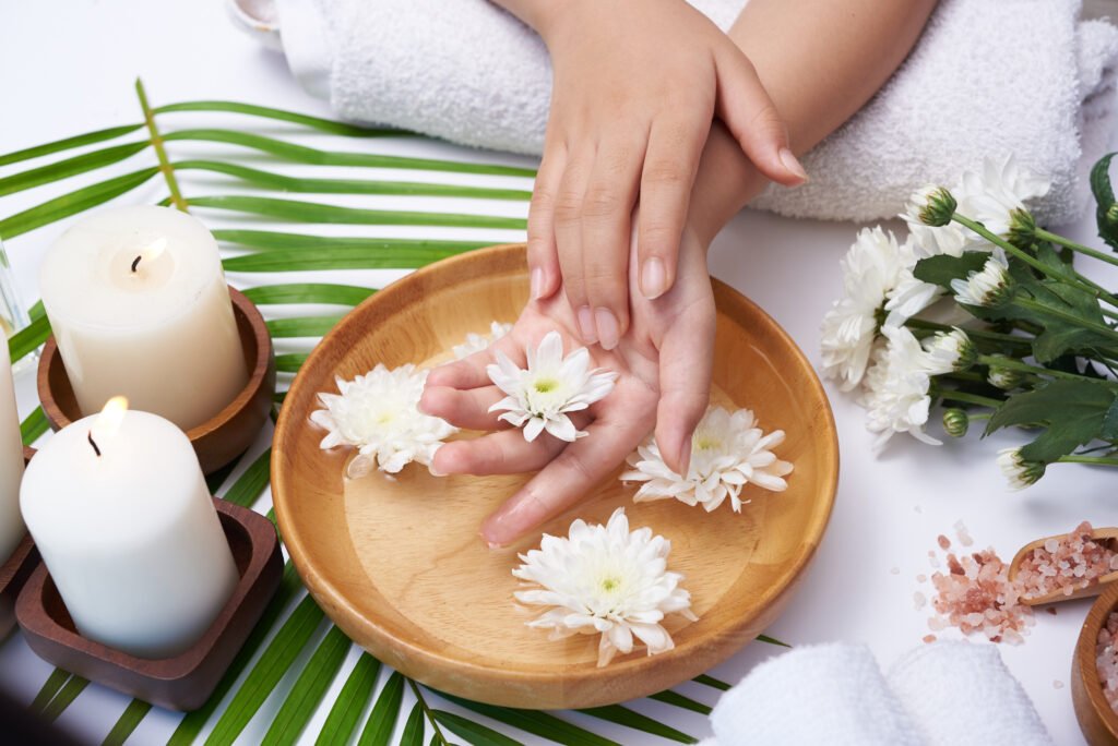 Elementor #2431 woman soaking her hands in bowl of water and flowers, spa treatm